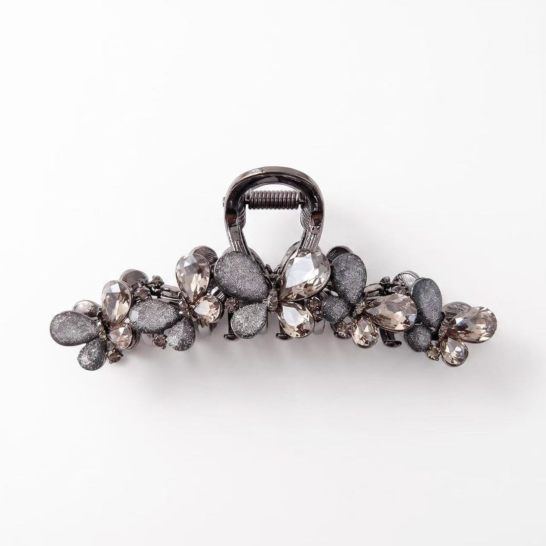 Dark butterfly hair claw clip with smoky rhinestones, textured fabric wings, and a gunmetal-tone frame